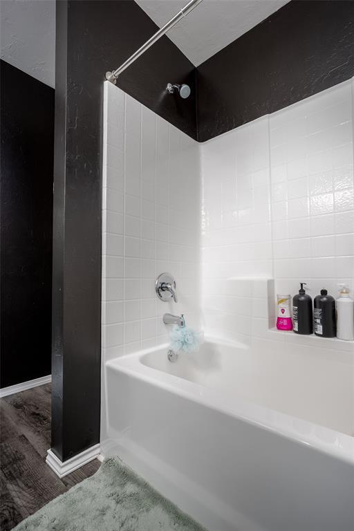 bathroom with wood-type flooring and shower / bathing tub combination