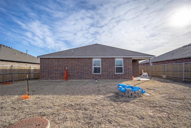 back of house with a fire pit