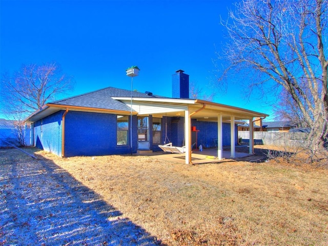 rear view of property featuring a patio area and a lawn