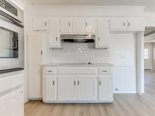 kitchen featuring black electric cooktop, white cabinets, and stainless steel oven