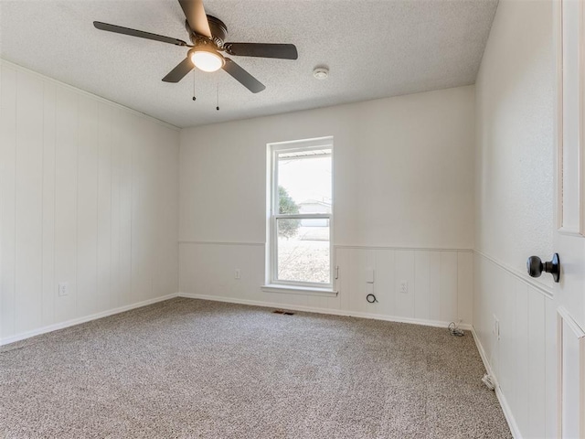 unfurnished room featuring ceiling fan, a textured ceiling, and carpet flooring