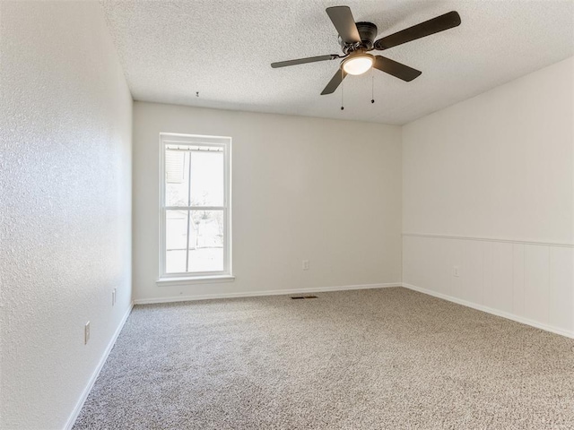 empty room featuring ceiling fan, carpet floors, and a textured ceiling