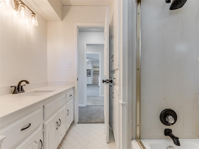 bathroom with vanity, crown molding, and washtub / shower combination