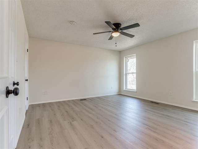 spare room with ceiling fan, a textured ceiling, and light wood-type flooring