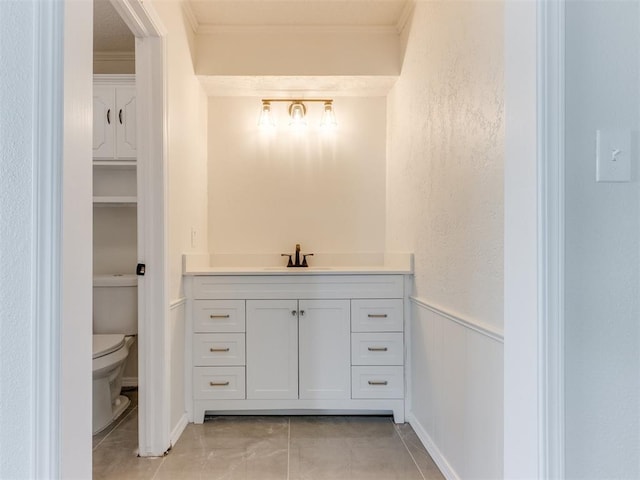 bathroom featuring vanity, crown molding, tile patterned floors, and toilet