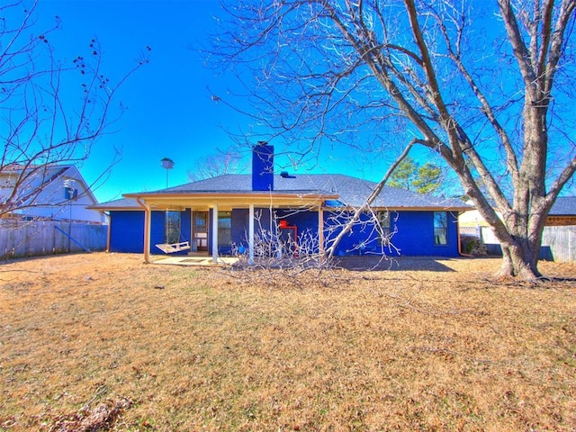 back of property with a patio area and a lawn