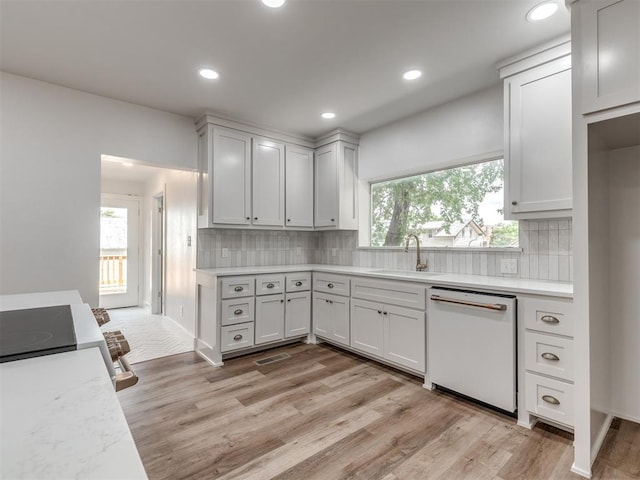 kitchen featuring plenty of natural light, white dishwasher, and white cabinets