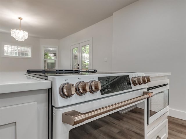 details featuring stove, hanging light fixtures, white cabinetry, and wood-type flooring