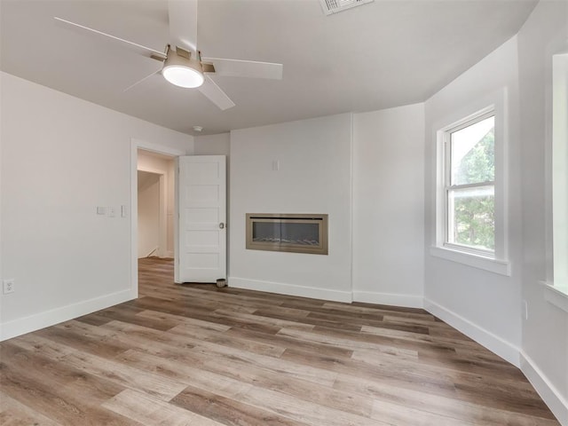 unfurnished living room featuring ceiling fan and light hardwood / wood-style flooring