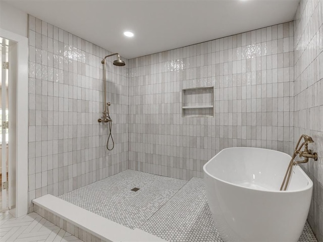 bathroom featuring shower with separate bathtub, tile walls, and tile patterned floors