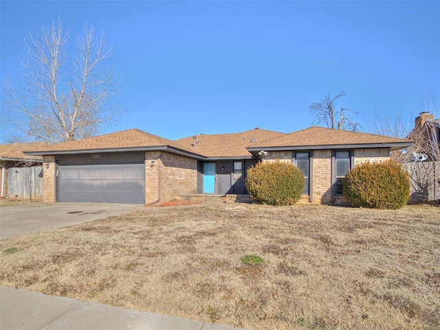 ranch-style home featuring a garage and a front lawn