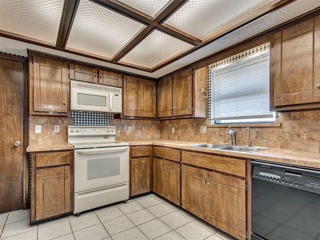 kitchen with light tile patterned flooring, white appliances, and sink