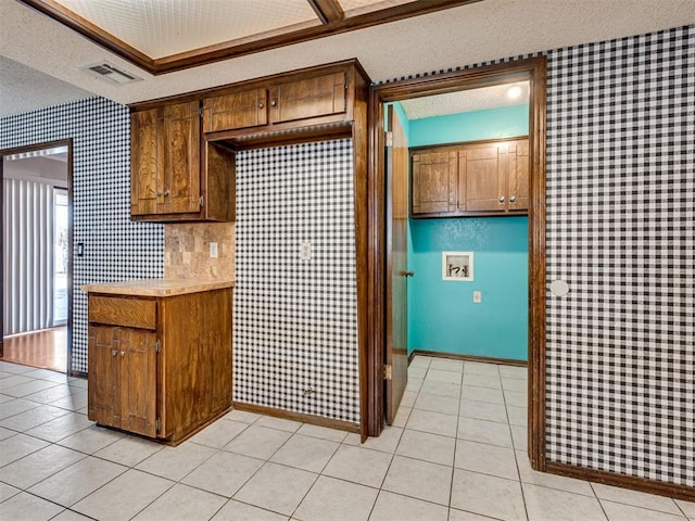 kitchen with light tile patterned floors, a textured ceiling, and decorative backsplash