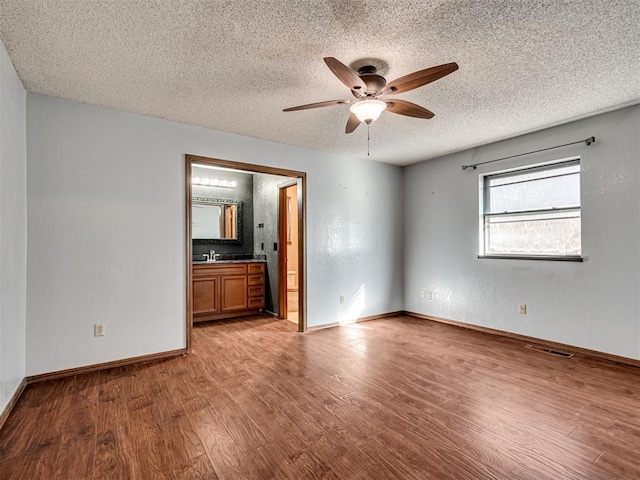 unfurnished room with ceiling fan, sink, a textured ceiling, and light wood-type flooring