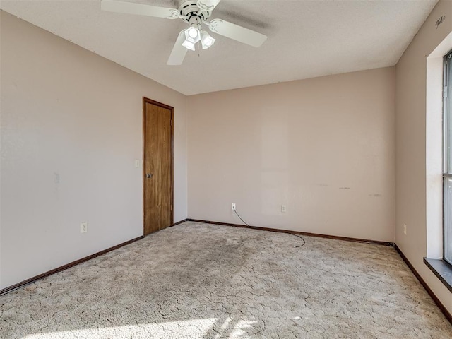 spare room with ceiling fan and light carpet