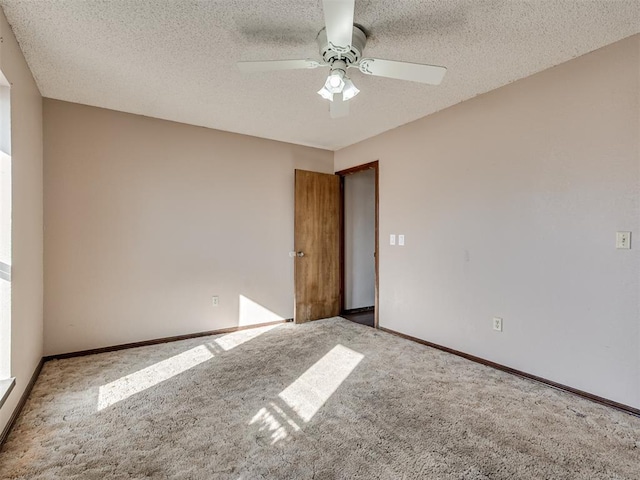 unfurnished room with ceiling fan, light colored carpet, and a textured ceiling