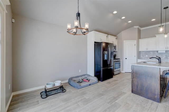 kitchen with decorative light fixtures, sink, white cabinets, decorative backsplash, and stainless steel appliances