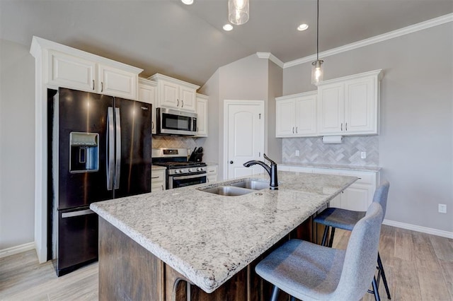 kitchen with stainless steel appliances, a kitchen island with sink, and white cabinets