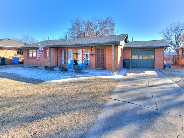 single story home with cooling unit and a garage