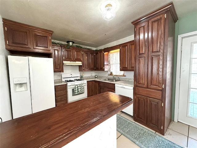 kitchen with sink, white appliances, and light tile patterned floors