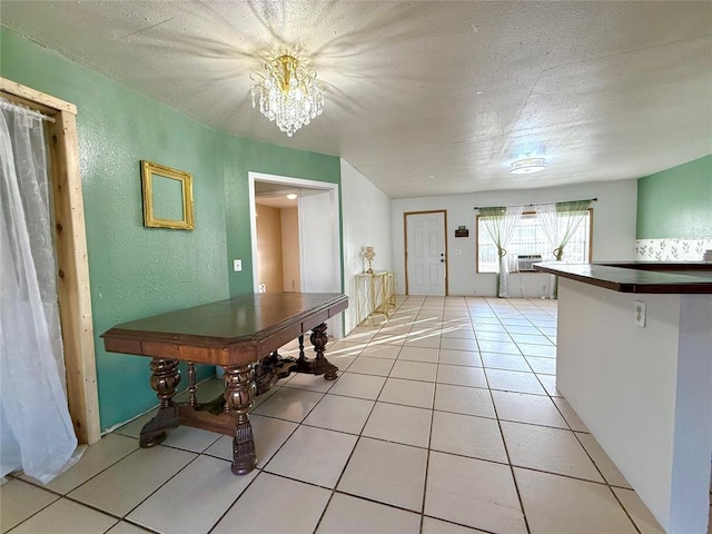 unfurnished dining area featuring a textured ceiling, light tile patterned floors, and an inviting chandelier