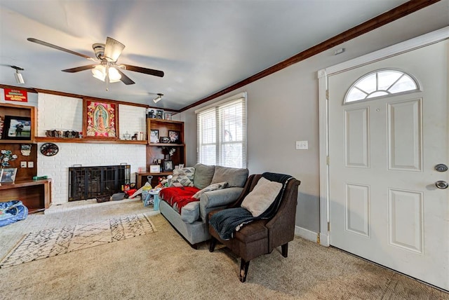 carpeted living room with a fireplace, ornamental molding, and ceiling fan