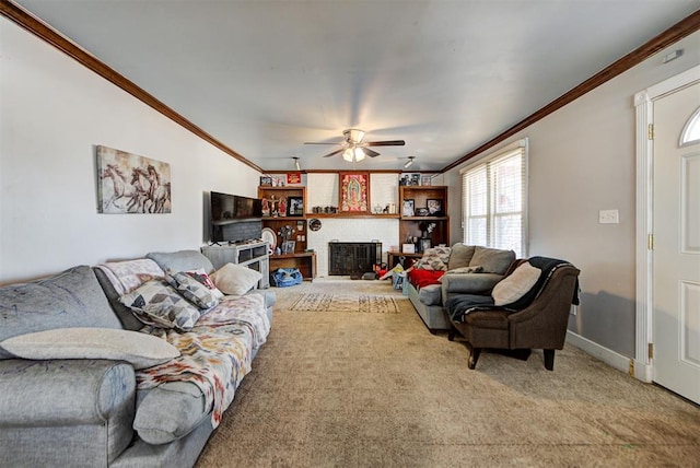 living room with a fireplace, crown molding, carpet floors, and ceiling fan