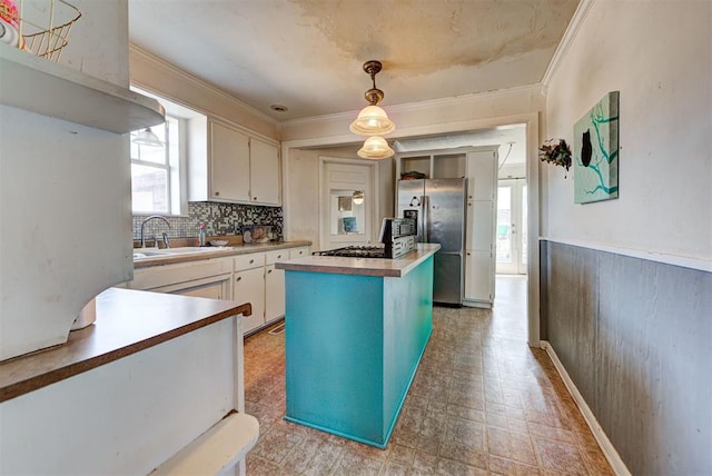 kitchen with sink, white cabinets, a kitchen island, stainless steel fridge with ice dispenser, and decorative light fixtures