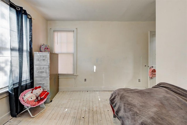 bedroom featuring multiple windows and light wood-type flooring