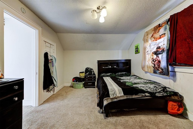 carpeted bedroom with lofted ceiling and a textured ceiling