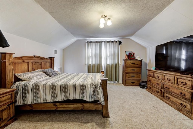 bedroom with lofted ceiling, light colored carpet, and a textured ceiling