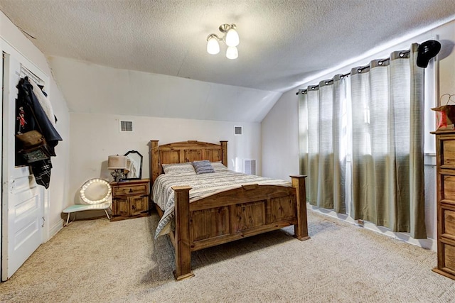 bedroom featuring lofted ceiling, light carpet, and a textured ceiling