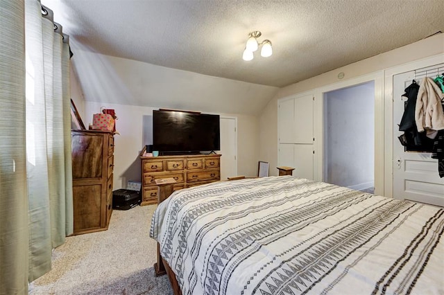 carpeted bedroom with vaulted ceiling and a textured ceiling