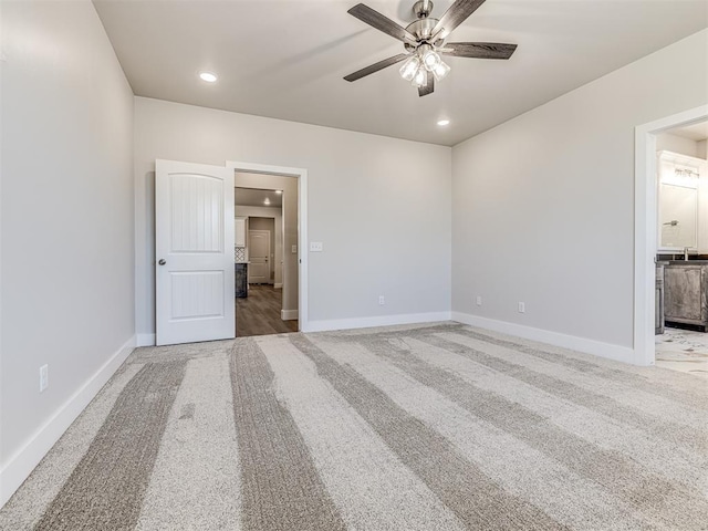 unfurnished bedroom with ensuite bathroom, carpet flooring, and ceiling fan