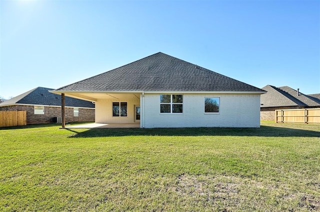 back of property featuring a patio and a lawn