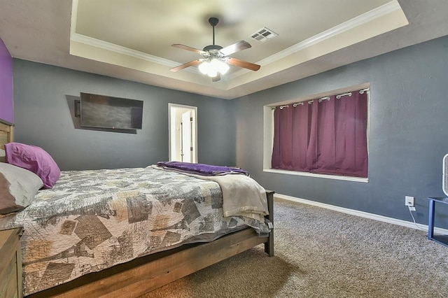 carpeted bedroom featuring ornamental molding, ceiling fan, and a tray ceiling