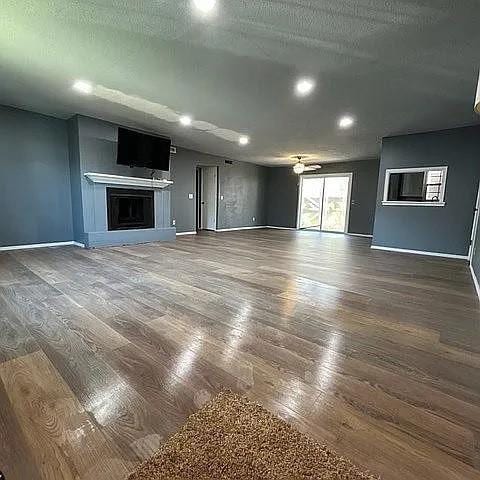 unfurnished living room with dark hardwood / wood-style floors and a textured ceiling