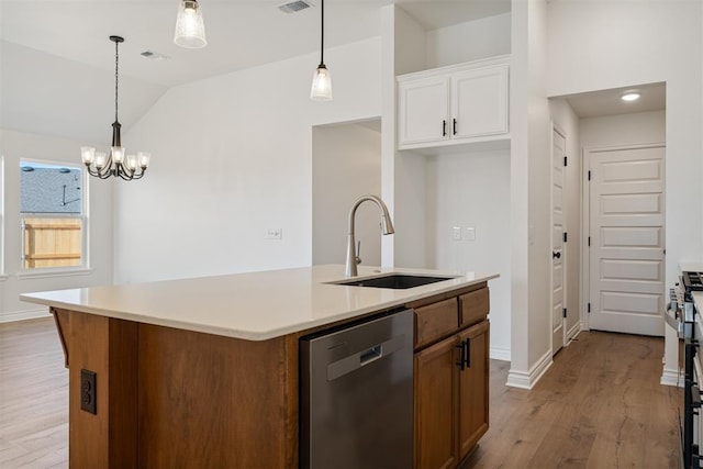 kitchen featuring pendant lighting, dishwasher, sink, white cabinets, and a center island with sink