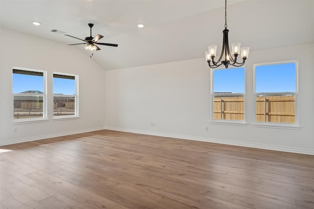 unfurnished room featuring vaulted ceiling, ceiling fan with notable chandelier, and hardwood / wood-style floors