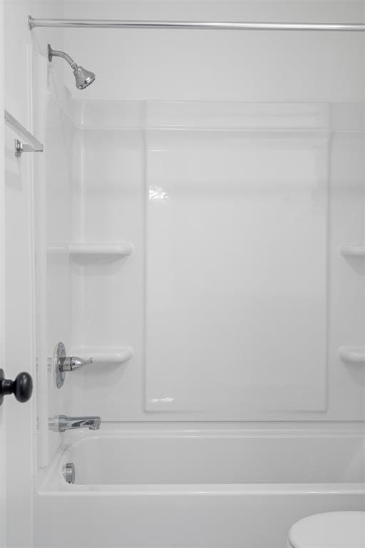 bathroom featuring bathtub / shower combination and toilet