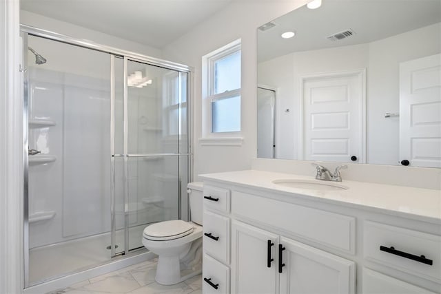 bathroom with vanity, toilet, and a shower with door