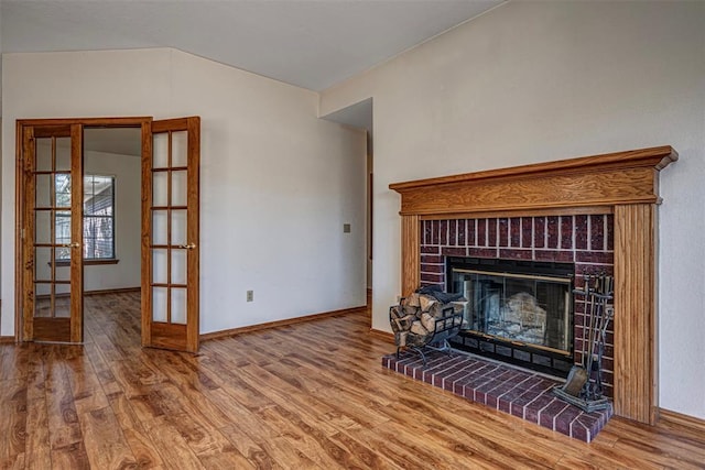 unfurnished living room featuring french doors, wood-type flooring, and a fireplace