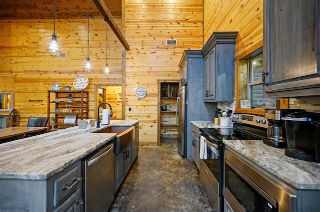 kitchen with stainless steel appliances, light stone countertops, sink, and decorative light fixtures