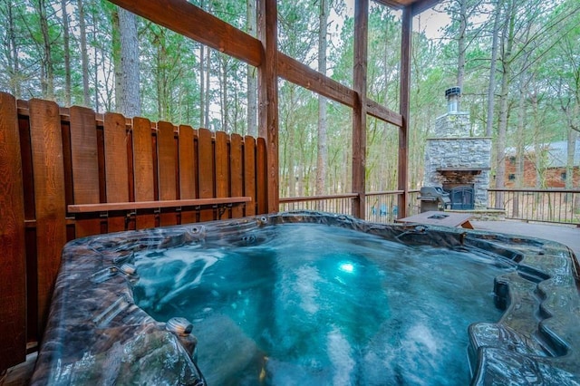 exterior space with a hot tub and an outdoor stone fireplace