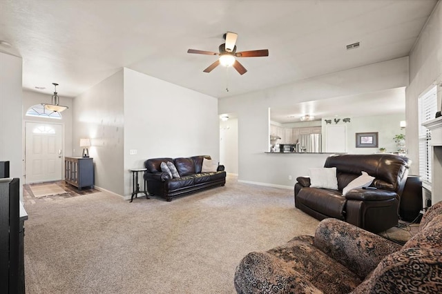 carpeted living room with ceiling fan