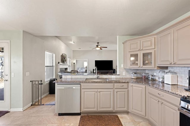 kitchen with stone counters, appliances with stainless steel finishes, sink, decorative backsplash, and ceiling fan