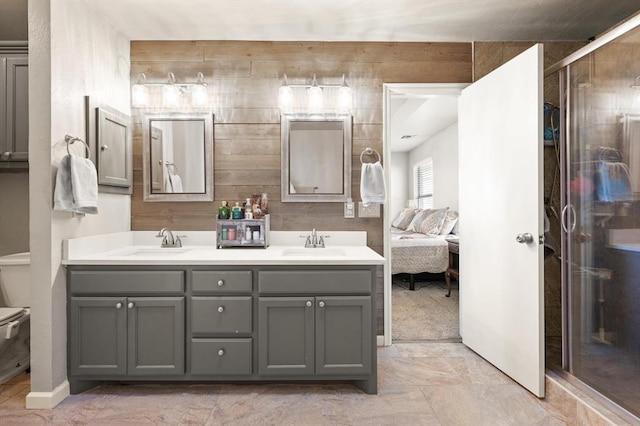 bathroom with toilet, vanity, wooden walls, and an enclosed shower