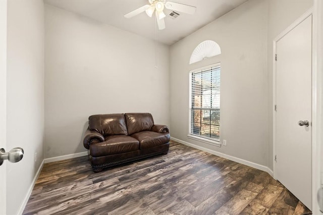 living area featuring dark wood-type flooring and ceiling fan