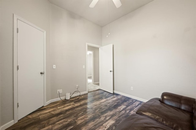 unfurnished room featuring a high ceiling, dark hardwood / wood-style floors, and ceiling fan