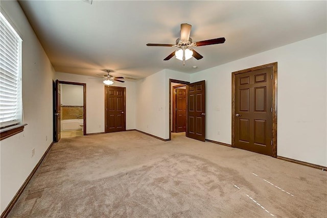 unfurnished bedroom with ceiling fan, light colored carpet, and ensuite bathroom